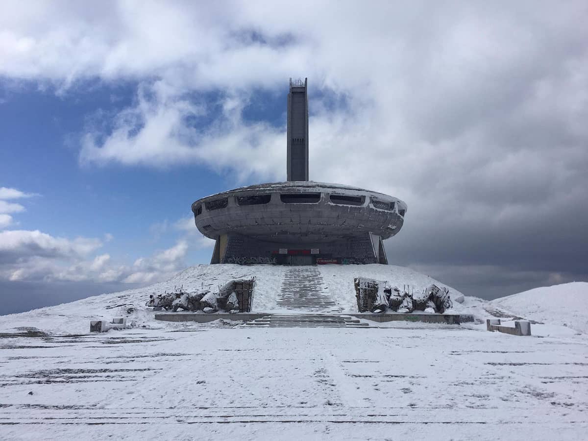 Snow-covered Buzludzha Monument in winter with main entrance and tower visible