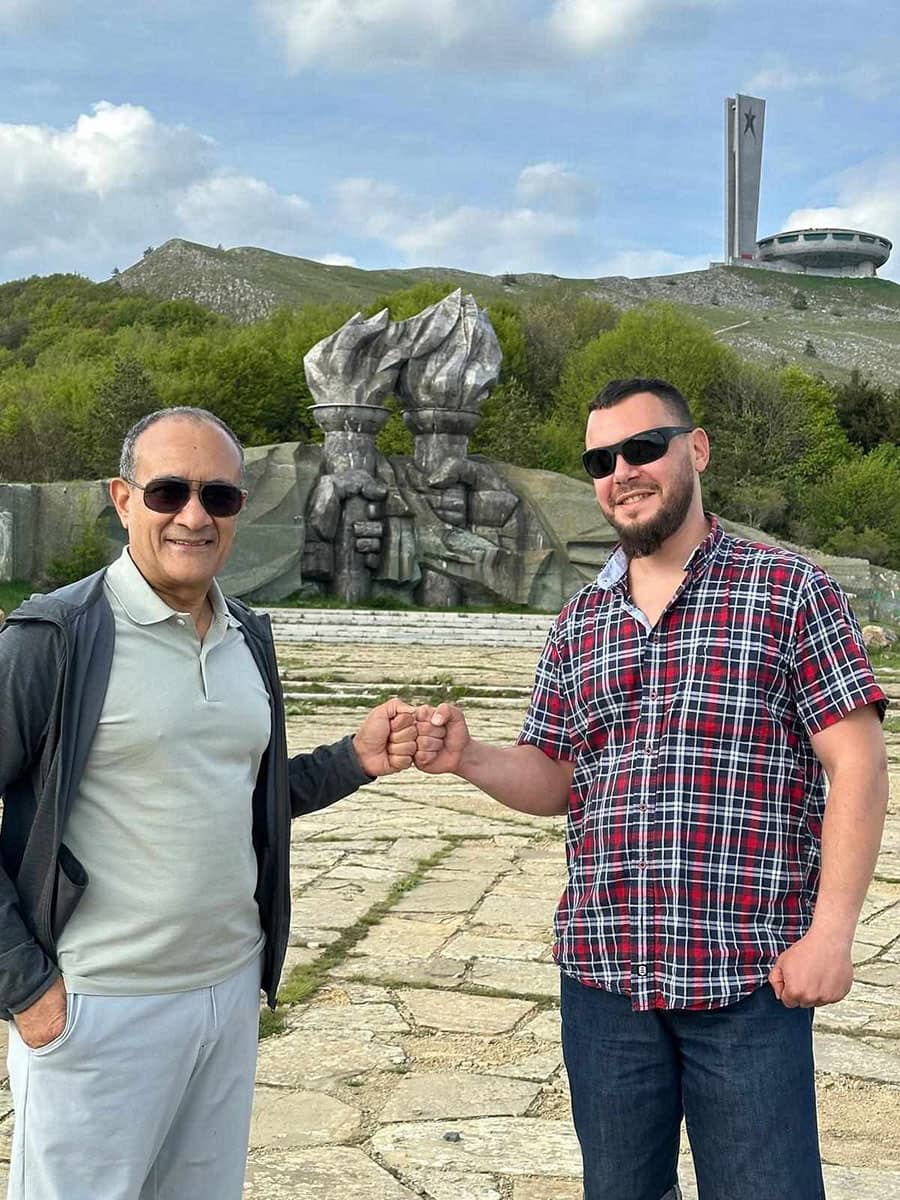 Our guide Kiril with a traveler at the socialist sculpture below Buzludzha Monument