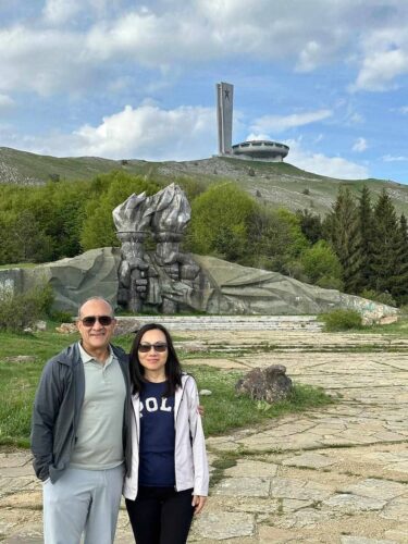 Couple posing at Buzludzha Monument socialist hands sculpture during guided tour